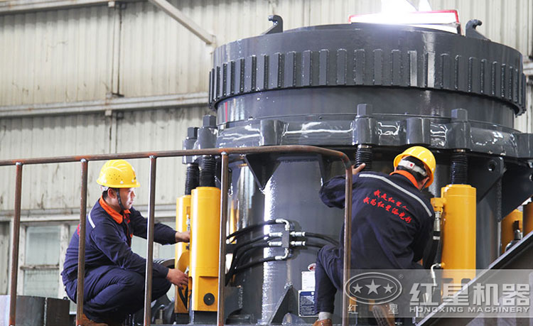 工作人員檢測圓錐破碎機，保障生產(chǎn)的設備都有高質(zhì)量